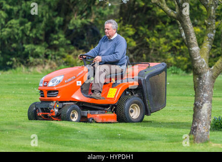 Homme âgé couper l'herbe à l'aide d'un Kubota GR1600 Ride sur la faucheuse. Banque D'Images