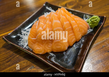 Sashimi au saumon sur une plaque en céramique noire avec partie de Wasabi Banque D'Images