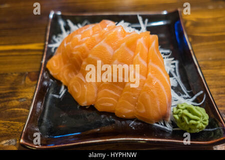 Sashimi au saumon sur une plaque en céramique noire avec partie de Wasabi Banque D'Images