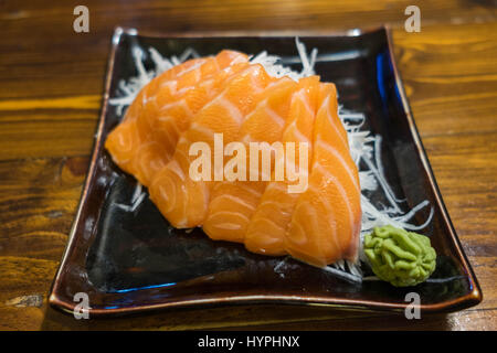 Sashimi au saumon sur une plaque en céramique noire avec partie de Wasabi Banque D'Images