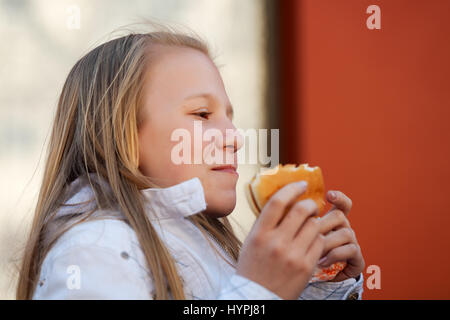 Teenage girl eating a burger Banque D'Images