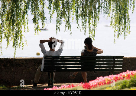 Jeune couple assis sur le banc à Ouchy au bord du Lac Léman, Lausanne, Suisse. Banque D'Images