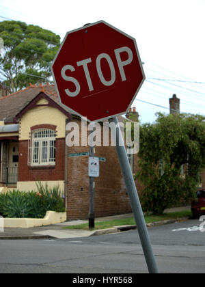 Stop rouge incliné d'un côté en Australie. Panneau stop pour avertir les conducteurs. Banque D'Images