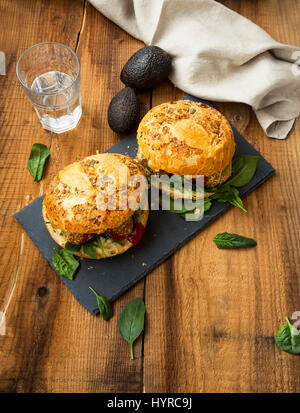 Burgers végétaliens sains avec des boules de falafel , les avocats et les feuilles d'épinards sur fond de bois Banque D'Images