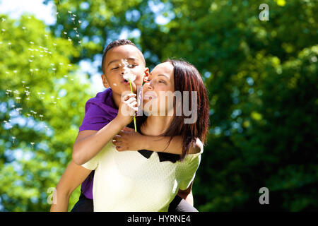 Close up portrait of a young mother with son usurpation de soufflage et le pissenlit Banque D'Images