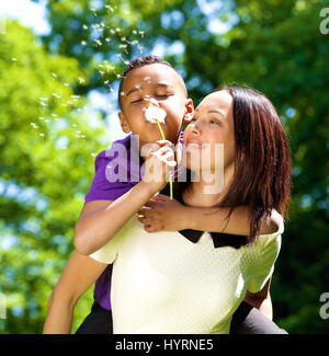 Close up portrait of a happy mère seule avec fils blowing dandelion Banque D'Images