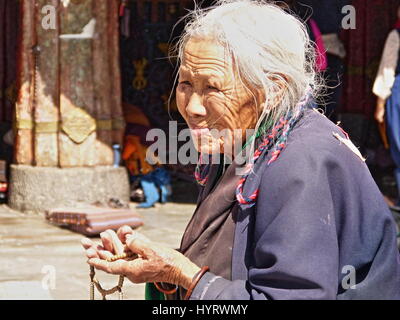 Une vieille femme Tibet avec son chapelet en face de Temple de Jokhang, également connu sous le nom de Qoikang ou monastère monastère Jokhang à Lhassa, Tibet Banque D'Images