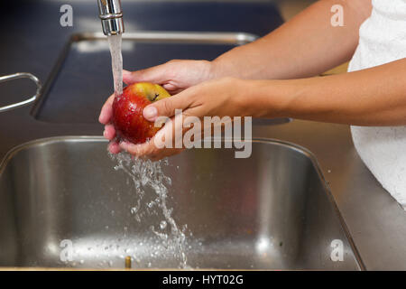Close up femme lave-mains sous l'eau dans le lavabo apple Banque D'Images