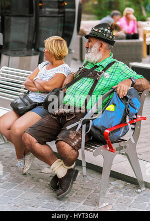 Zermatt, Suisse - le 24 août 2016 : des gens assis sur le banc. Homme avec moustache portant costume traditionnel Suisse avec un short en cuir Banque D'Images