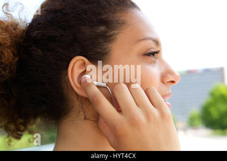 Young african american woman écoutez de la musique avec des écouteurs dans les oreilles Banque D'Images