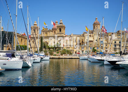 Les yachts et bateaux amarrés dans le port de l'arsenal de creek en face de l'église Saint-Laurent. Birgu, Malte. Banque D'Images