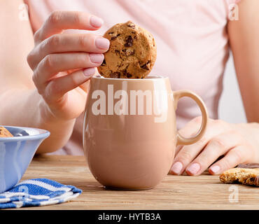 Femme mains avec tasse de thé et des cookies. Selective focus Banque D'Images