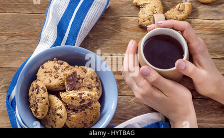 Femme mains avec tasse de thé et des biscuits pour le petit déjeuner. Vue d'en haut Banque D'Images