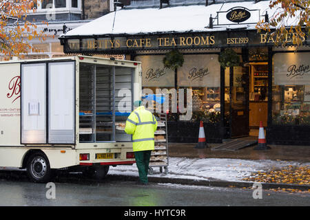 Bradford, West Yorkshire, Royaume-Uni. Livraison Frais du matin est arrivée par van dans la neige. Miches de pain pour Bettys Café déchargés sur des plateaux par l'homme en hi-vis. Banque D'Images