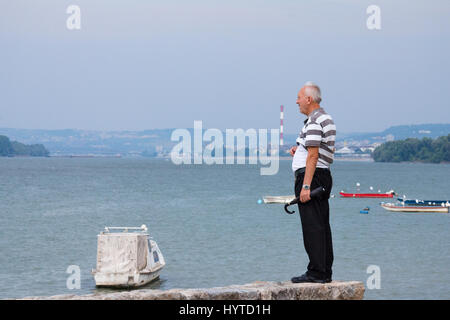 BELGRADE, SERBIE - Août 2, 2015 : l'observation d'un homme de Belgrade centre et le Danube à partir de la banlieue de Zemun sur un jour nuageux Photo d'un homme de l Banque D'Images