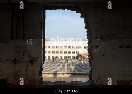 Gros trou dans le mur d'un bâtiment industriel, un ancien laboratoire qui a fait faillite lors de la crise économique. Une autre grande usine bui Banque D'Images