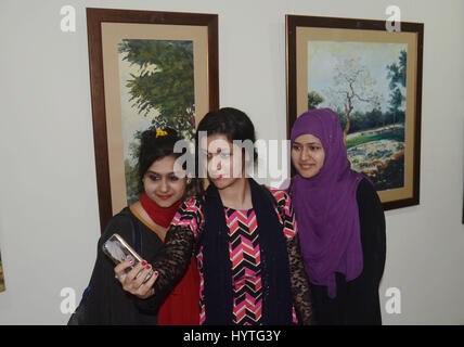 Lahore, Pakistan. 07Th avr, 2017. Visiteurs pakistanais prendre un vif intérêt dans des photos durant l'exposition de groupe de jeunes artistes 2017 tenue à la galerie d'Art Coopérative à Lahore. Credit : Rana Sajid Hussain/Pacific Press/Alamy Live News Banque D'Images