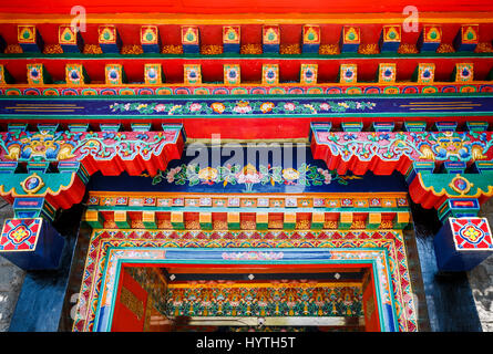 Détail de l'ornementation des avant-toits colorés au-dessus de la porte d'entrée de l'Institut Norbulingka, Sidphur, Dharamsala, Inde du nord, de l'Himachal Dharampur Banque D'Images