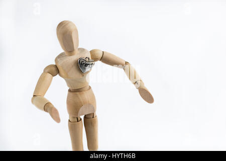 Un mannequin articulé en bois mannequin avec bras en position hug ami coeur sur la poitrine. Banque D'Images