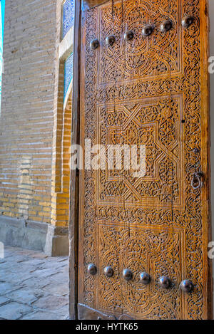 Vieille porte en bois sculpté d'ornement dans la vieille ville de Khiva, Ouzbékistan Banque D'Images