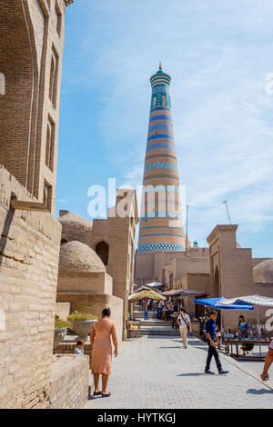 KHIVA, OUZBÉKISTAN - 7 septembre : Les gens qui marchent dans la rue étroite de la vieille ville de Khiva et minaret derrière. Septembre 2016 Banque D'Images