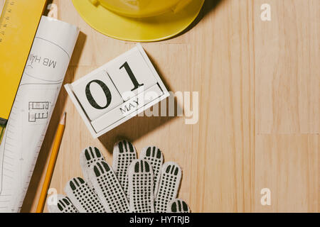 Le 1er mai. Droit de mai 1 blocs blanc calendrier en bois avec des outils de construction sur la table. La Journée internationale du Travail. Concept de la fête du travail. Banque D'Images