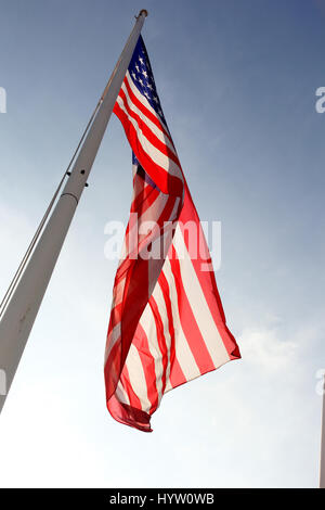 Un drapeau américain vagues contre un ciel bleu. Banque D'Images