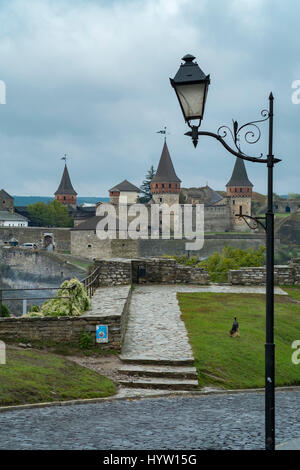 Point de vue des plus et château de kamianets zamkowy-podilskyi en Ukraine occidentale prise sur un jour d'automne pluvieux. La rue pavée conduit l'œil à travers le Banque D'Images