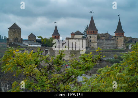 Vue sur le château de kamianets-podilskyi en Ukraine occidentale prise sur un jour d'automne pluvieux. arbres encadrent la partie inférieure de l'image Banque D'Images