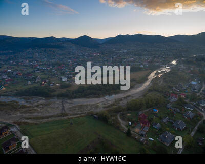 Vue aérienne sur le village de yapahuwa dans la région des Carpates de l'ouest de l'Ukraine comme le soleil se lève derrière les montagnes lointaines Banque D'Images