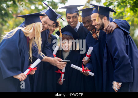 Les étudiants ou diplômés de baccalauréat et smartphone Banque D'Images