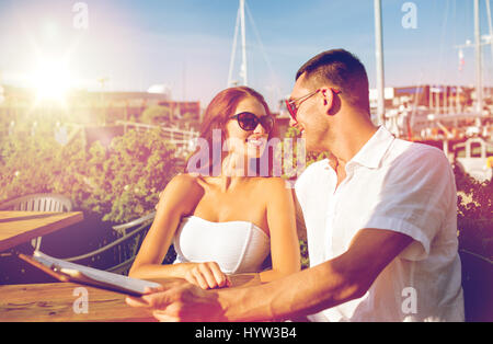 Smiling couple avec menu au café Banque D'Images
