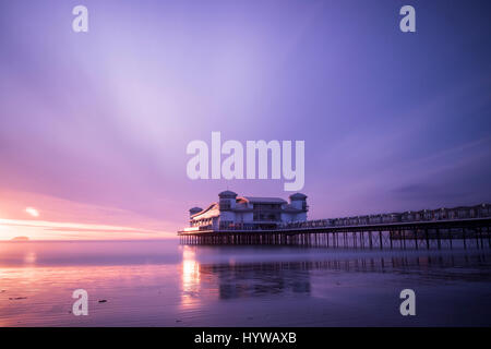 Grand Pier à Weston Super Mare reflétée dans le sable humide et la mer au coucher du soleil Banque D'Images