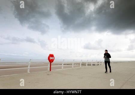 Muro, Denbighshire, Wales, UK. 27 avril 2017. Météo France pour les vacances de l'air mélangé et beaucoup vont voir cool, ciel couvert avec de la pluie par moments. C'est un vent froid et pluvieux parfois à la station côtière de Muro dans le Nord du Pays de Galles avec une brise de nord froid venant de mer comme une femme devient un peu tôt le matin dans la remise en forme le long de la promenade à entre gratuites © DGDImages/Alamy Live News Banque D'Images