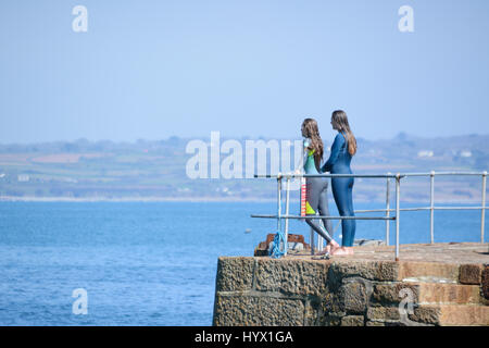 Mousehole, Cornwall, UK. 7 avril 2017. Météo britannique. Après-midi ensoleillé à Mousehole, avec les filles de sauter les murs du port dans la mer. Crédit : Simon Maycock/Alamy Live News Banque D'Images