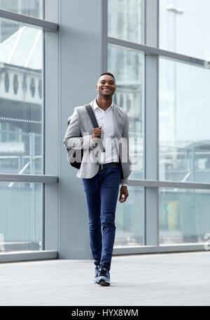 Portrait d'un beau jeune homme marchant à la station avec sac Banque D'Images