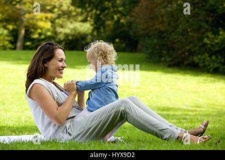 Portrait d'une belle mère jouant avec cute baby outdoors Banque D'Images