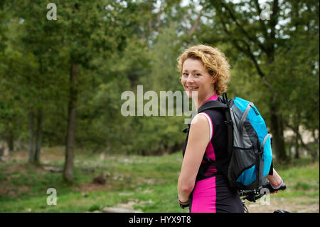 Portrait of a young woman smiling with bicycle Banque D'Images