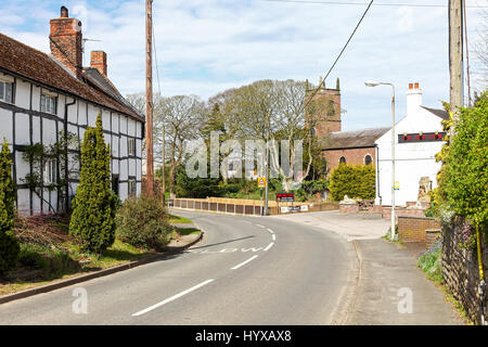 Une vue vers le bas chemin Station montrant St Luke's Church, cottage et le lion rouge public house ou pub dans le village de Goostrey, Cheshire, England, UK Banque D'Images