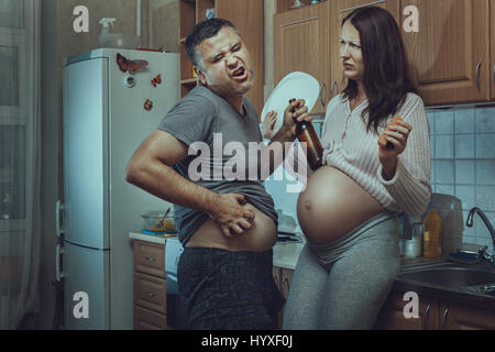 L'homme ivre dans la cuisine, à côté d'une femme enceinte. Les problèmes sociaux de la famille. Banque D'Images
