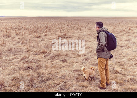 Randonneur et de chien de prairie en repos sur un jour nuageux Banque D'Images