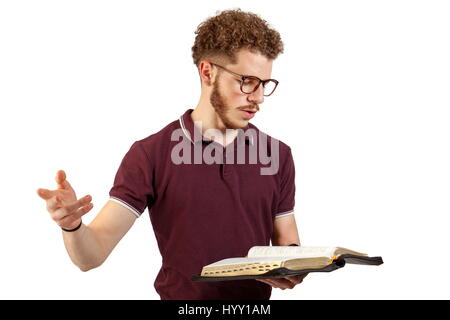 Jeune homme en train de lire la bible sur fond blanc Banque D'Images