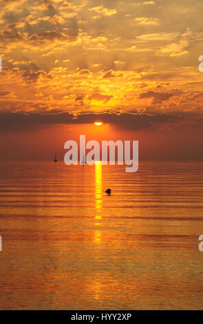 Lever du soleil d'or sur la mer baltique à Gdynia, Pologne - nuages et soleil en silhiuette bateau sur l'horizon - heure d'or Banque D'Images