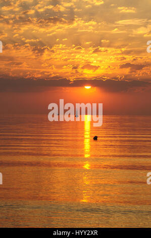 Lever du soleil d'or sur la mer baltique à Gdynia, Pologne - nuages et soleil en silhiuette bateau sur l'horizon - heure d'or Banque D'Images