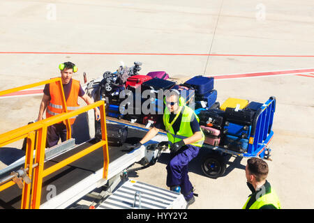 Bagagistes le chargement d'un avion sur le tarmac de l'aéroport de Barcelone, Catalogne, Espagne Banque D'Images