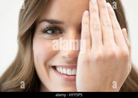 Mid adult woman couvrant les yeux avec la main. Banque D'Images