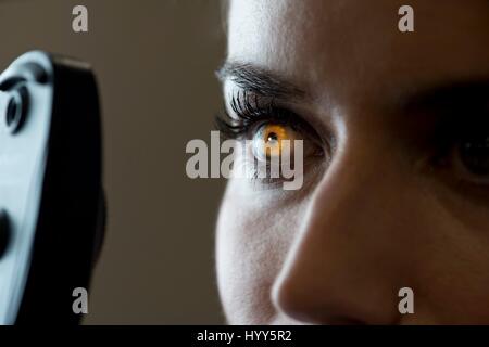 Woman having eye test avec lumière brillant dans iris. Banque D'Images