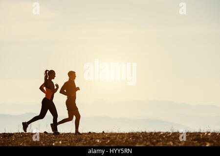 Couple de coureurs en toile de fond les montagnes de steppe Banque D'Images