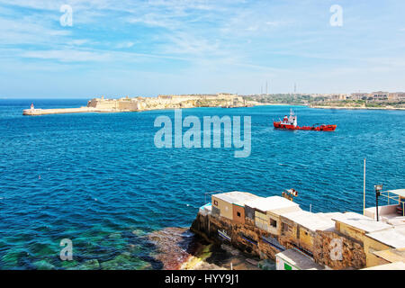 Navire à cargaison sèche et brise-lames à Fort Ricasoli de Kalkara au grand port de La Valette, Malte Banque D'Images