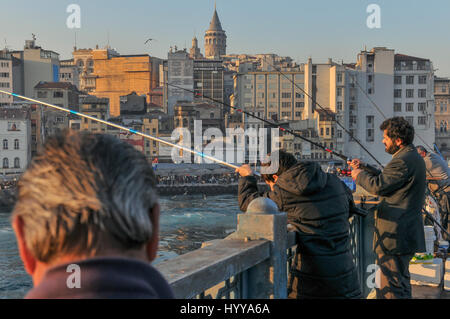 Pêcheurs sur le pont de Galata. La tour de Galata peut être vu dominant les toits de Beyo ?lu dans l'arrière-plan. Banque D'Images